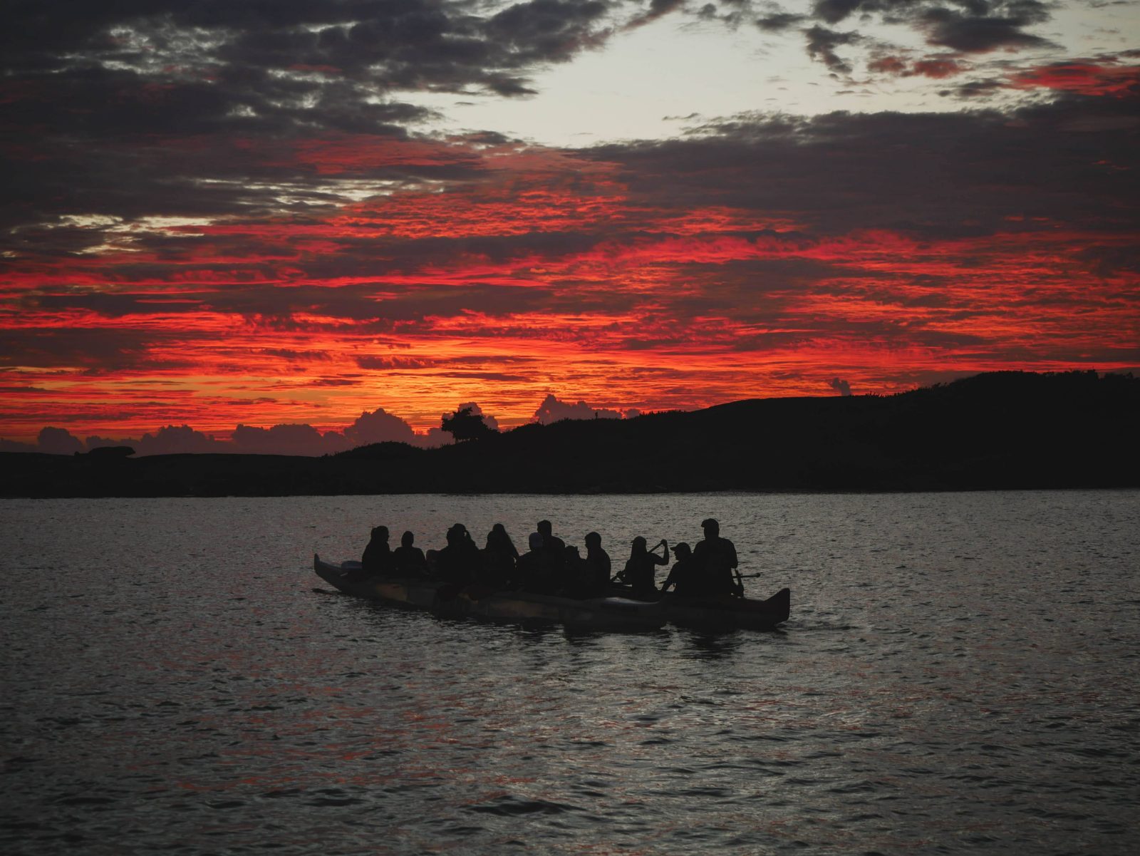 Canoa silhueta no nascer do sol vermelho