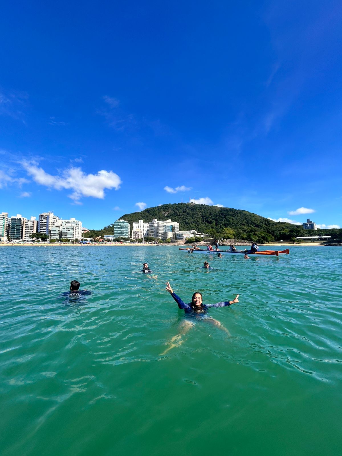 Mergulho no mar com canoa ao fundo
